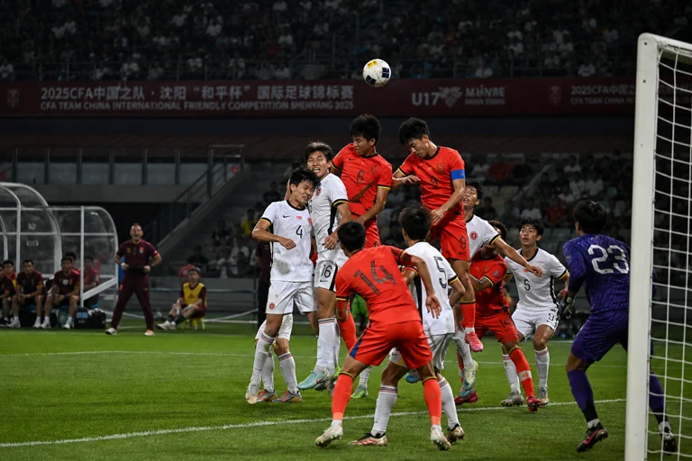 U17国足比赛画面,球员在角球进攻中争顶